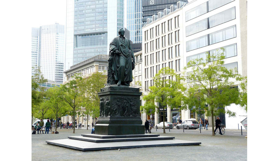 Goethe-Denkmal, Zu sehen ist das bronzene Denkmal für Johann Wolfgang von Goethe auf dem Goetheplatz. Über einem hohen Sockel erhebt sich die monumentale Statue des Dichters. Er hält eine Schriftrolle und einen Lorbeerkranz. Den Sockel schmücken Reliefs mit Figuren aus Goethes Werken., Foto: Eva Burger